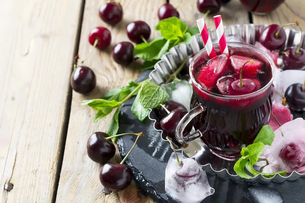 Suco de cereja fresco em um copo com gelo em um fundo de madeira. Estilo rústico. Foco seletivo . — Fotografia de Stock