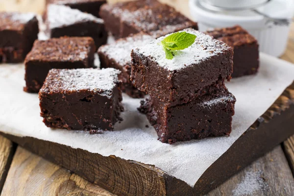 Coklat brownies dengan bubuk gula dan ceri pada latar belakang kayu yang gelap. Fokus selektif . — Stok Foto