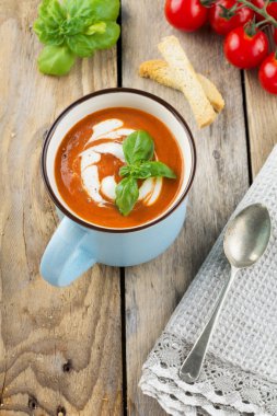 Eski ahşap arka plan üzerinde seramik bir fincan domates çorbası. Seçici odak.