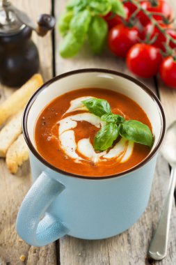 Eski ahşap arka plan üzerinde seramik bir fincan domates çorbası. Seçici odak.