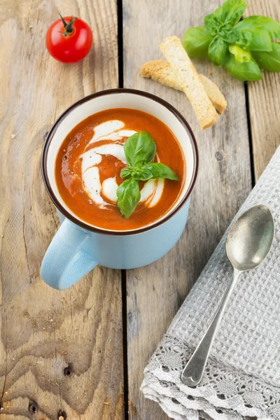 Soupe de tomates dans une tasse en céramique sur le vieux fond en bois. Concentration sélective . — Photo