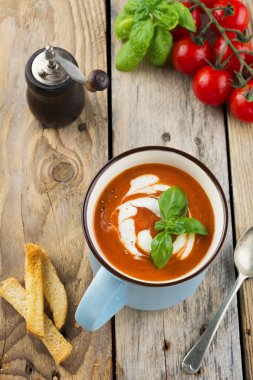 Eski ahşap arka plan üzerinde seramik bir fincan domates çorbası. Seçici odak.
