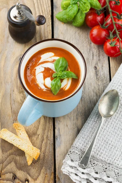 Soupe de tomates dans une tasse en céramique sur le vieux fond en bois. Concentration sélective . — Photo