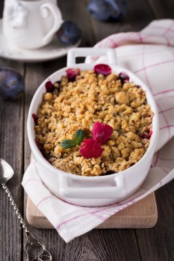 Erik ve ahududu kırıntı eski ahşap arka plan üzerinde. Rustik tarzı. Seçici odak.