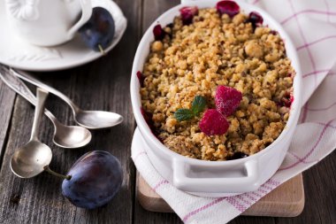 Erik ve ahududu kırıntı eski ahşap arka plan üzerinde. Rustik tarzı. Seçici odak.