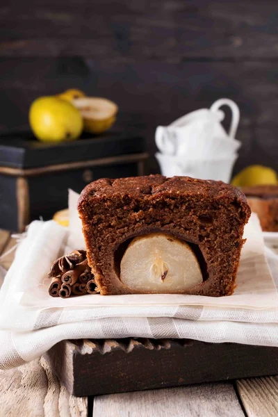 Çikolatalı kek ile armut ve eski ahşap zemin üzerine tarçın. Seçici odak.