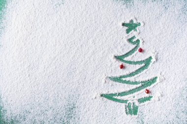 Un yeşili arka plana boyanmış Noel ağacı ve küçük oyuncaklarla metin yazmak için bir yer. Yukarıdan görüntüle.