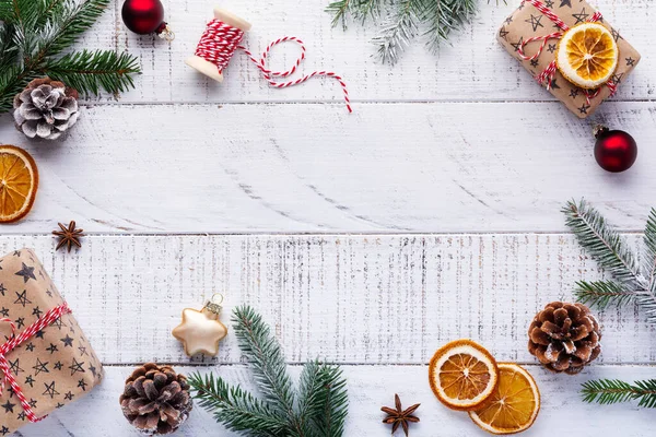 Weihnachtlicher Hintergrund Mit Tannenzweigen Tannenzapfen Geschenkbox Getrockneten Orangen Sternanis Und — Stockfoto