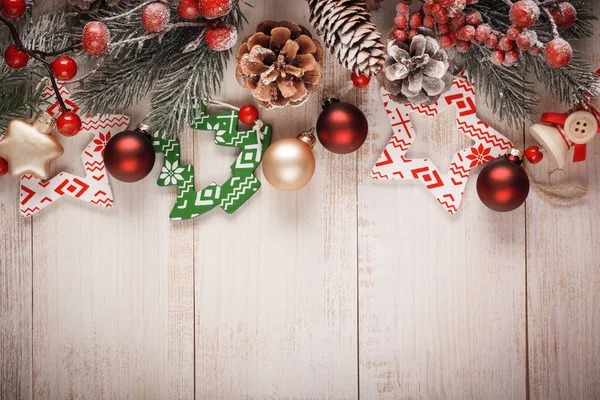 圣诞节背景 老木板上有冷杉枝条 松果和浆果 玻璃和木制的圣诞玩具 复古格子 — 图库照片