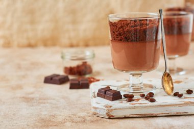 Hafif kayrak, taş ya da beton arka planda cam kavanozlarda brovnili leziz tatlı çikolatalı mus. Seçici odak.