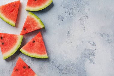 Mavi beton arka planda buzlu taze karpuz dilimleri. Detoks ve vejetaryen konsepti. Üst görünüm, kopyalama alanı, afiş