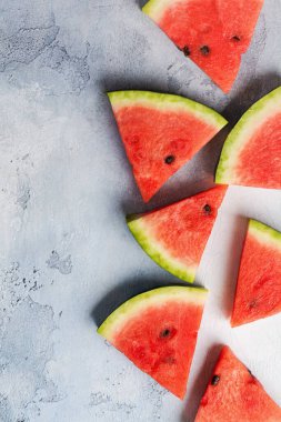 Mavi beton arka planda buzlu taze karpuz dilimleri. Detoks ve vejetaryen konsepti. Üst görünüm, kopyalama alanı, afiş