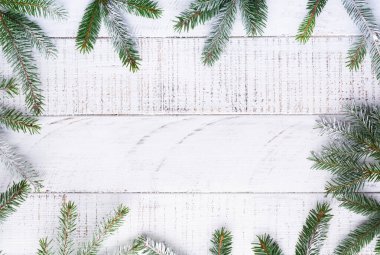 Noel arkaplanı köknar dalları, kozalaklar, hediye kutusu, kurutulmuş portakallar, eski beyaz tahta üzerinde yıldız anason ve böğürtlenler. Üst görünüm.