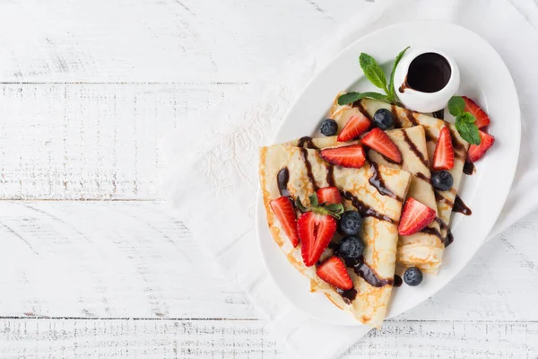 메이드 초콜릿 소스를 곁들인 맛있는 팬케이크 식사로 딸기와 위에서 — 스톡 사진