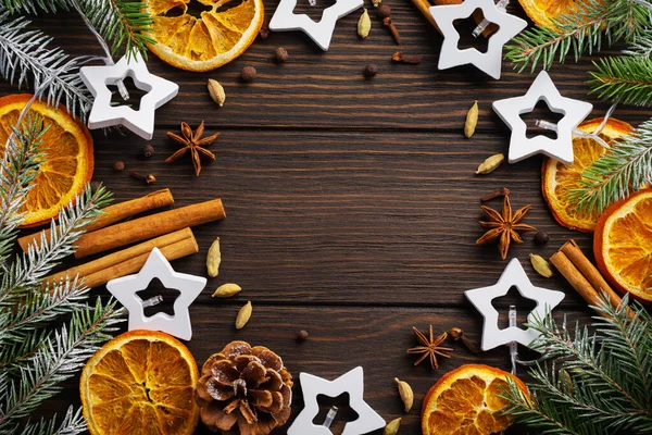 圣诞节或新年背景 冷杉分枝与干橙 豆蔻和覆膜的葡萄酒香料 洒落黑暗的木制背景 放在你的文字位置上 — 图库照片