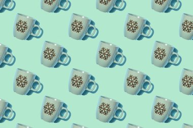 Yaratıcı bir Noel modeli. Açık yeşil arka planda kar taneleri desenli boş bardak. Yaratıcı bir Noel modeli. Üst Manzara. Duvar kağıdı, tekstil, arka plan, poster, kitap kapağı, kartpostallar için iyidir.