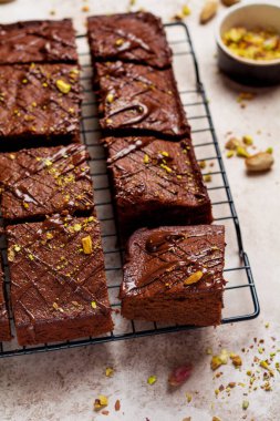 Fıstıklı çikolatalı kareler ve beyaz arkaplanda beyaz kağıt üzerinde çilek, üst manzara, yatay kompozisyon. Düz yiyecek..