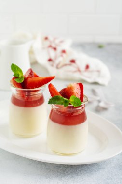 Festive dessert with berry jelly, vanilla panna cota and fresh strawberry on gray concrete table background. Selective focus. clipart