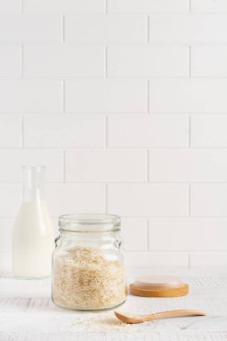 Çiğ beyaz pirinç, İtalyan pilav tabakları için beyaz beton ya da taş zemin üzerinde cam kavanoz içinde Arborio. Seçici odaklanma. Boşluğu kopyala.