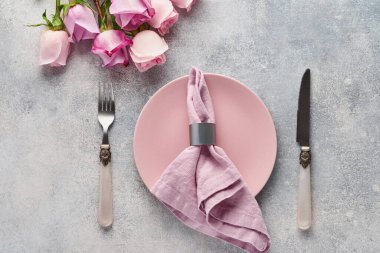 Gri masa üzerinde çiçek dekoru olan Paskalya sofrası. Zarif bir akşam yemeği. Model yap. Üst görünüm.