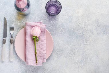 Gri masa üzerinde çiçek dekoru olan Paskalya sofrası. Zarif bir akşam yemeği. Model yap. Üst görünüm.