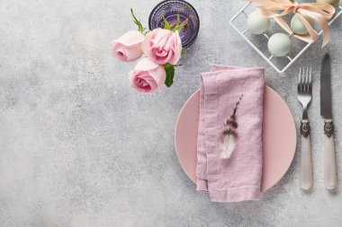 Gri masa üzerinde çiçek dekoru olan Paskalya sofrası. Zarif bir akşam yemeği. Model yap. Üst görünüm.