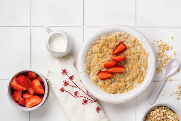 简单的燕麦粥粥 上面有草莓和白盘的亚麻布餐巾 早餐健康食品的概念 顶部视图 — 图库照片