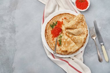 Krep, ince krep, gri tabakta kırmızı havyarlı Rus gözlemesi. Mermer arka plan. Uzayı kopyala Üst görünüm.