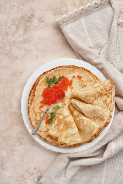 Krep, ince krep, gri tabakta kırmızı havyarlı Rus gözlemesi. Mermer arka plan. Uzayı kopyala Üst görünüm.