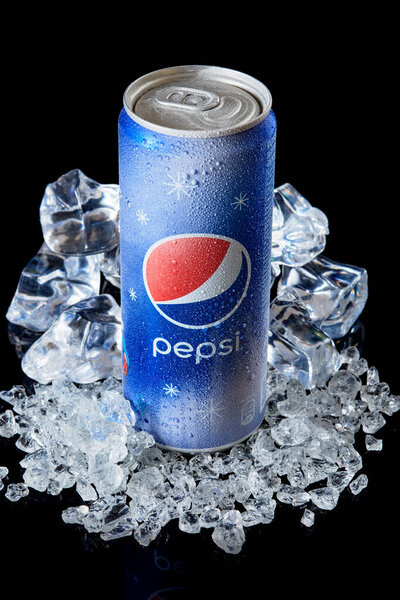 MOGILEV, BELARUS FEBRUARY 13 2021: Can of Pepsi cola on ice over black background, Pepsi is a carbonated soft drink produced PepsiCo. Created in 1893