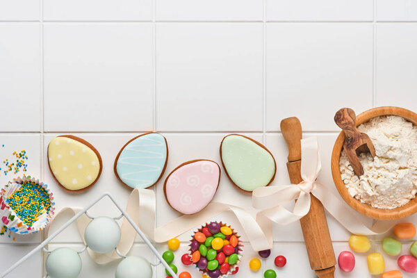 Easter baking background. Concept of cooking traditional festive food Easter gingerbread and bread on white background. Spring cooking time. Space for a text.