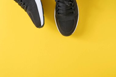 Sarı arka planda siyah erkek ayakkabıları. Moda blogu ya da dergi konsepti. Erkek ayakkabıları, moda spor ayakkabıları, moda, yaşam tarzı. Model yap. Düz görünüm kopyalama alanı en az arkaplan.