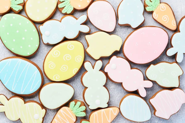 Çok renkli Paskalya zencefilli ekmeği, şeker ve gri arka planda dağınık şekerleme sosu. Paskalya pişirme geçmişi. Kutlama geçmişi konsepti. Metin için boşluk.