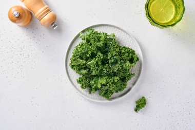 Açık gri taştan arka planda bir kase taze doğranmış lahana. Sağlıklı salata yapmak için gerekli malzemeler. Temiz yemek, detoks ya da diyet konsepti. Model.