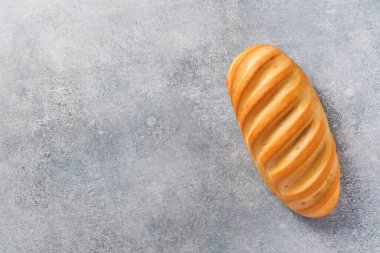 Açık gri beton arka planda taze ekmek. Metin için boşluk olan üst görünüm