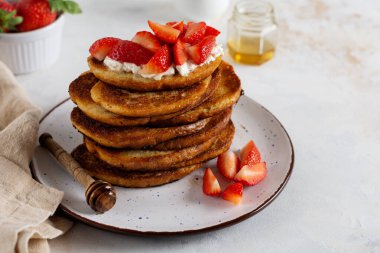 Kahvaltı için süzme peynirli, ballı ve çilekli bir yığın Fransız tostu. Seçici odak