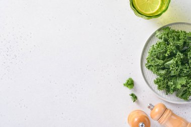 Açık gri taştan arka planda bir kase taze doğranmış lahana. Sağlıklı salata yapmak için gerekli malzemeler. Temiz yemek, detoks ya da diyet konsepti. Model.