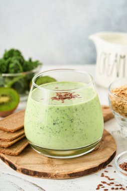 Lahana, ıspanak ve kiviyle detoks yeşil smoothie açık gri kayrak, taş veya beton arka plan. Kopyalama alanı olan üst görünüm.