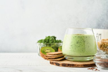 Lahana, ıspanak ve kiviyle detoks yeşil smoothie açık gri kayrak, taş veya beton arka plan. Kopyalama alanı olan üst görünüm.