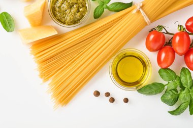 Spagetti, taze domates, otlar ve baharatlar. Sağlıklı besin bileşenleri beyaz arka planda izole, üst görünüm