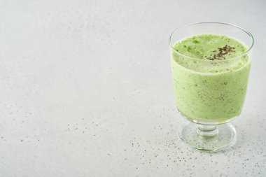 Lahana, ıspanak ve kiviyle detoks yeşil smoothie açık gri kayrak, taş veya beton arka plan. Kopyalama alanı olan üst görünüm.