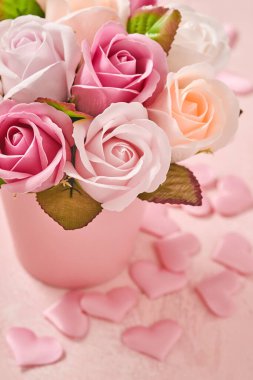 Açık pembe arka planda pembe yuvarlak kutuda güzel narin güller olan şenlikli bir kompozisyon. Düz konum, kopyalama alanı. Tebrik kartı.