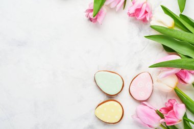 Paskalya sofrasında çiçek dekoru ve beyaz masada paskalya zencefilli ekmek. Zarif bir akşam yemeği. Model yap. Üst görünüm.