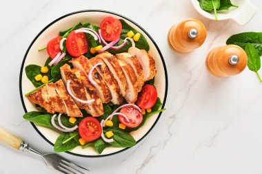 Salata ıspanaklı tavuk filetosu, kiraz domatesleri, çiçek ve soğan. Sağlıklı yiyecekler. Keto diyeti, diyet öğle yemeği konsepti. Beyaz arkaplanda üst görünüm.