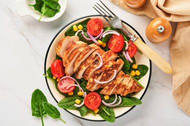 Salata ıspanaklı tavuk filetosu, kiraz domatesleri, çiçek ve soğan. Sağlıklı yiyecekler. Keto diyeti, diyet öğle yemeği konsepti. Beyaz arkaplanda üst görünüm.