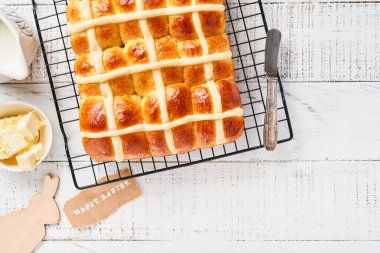 Paskalya Sıcak Çörekleri. Geleneksel kahvaltı ve Paskalya pastası dekorasyonu Rabbiton beyaz ahşap arka plan. Parlak renkler, yukarıdan ahşap masa manzarası.