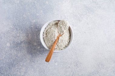 Eski gri beton arka planda seramik bir kasede kapalı bir kolajen. Kopyalama alanı olan düz