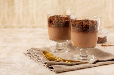 Hafif kayrak, taş ya da beton arka planda cam kavanozlarda çikolatalı mus. Lezzetli tatlı. Seçici odak