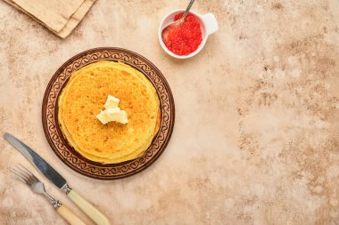 Krep ya da tereyağlı ince gözleme yığını ve eski kahverengi arka planda seramik tabakta kırmızı havyar. Üst görünüm, boşluğu kopyala. Kahvaltı ya da tatlı için ev yapımı ince krep..