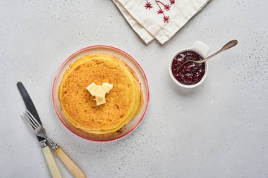 Krep ya da tereyağlı ve ahududu reçelli ince krepler eski gri beton arka planda güzel bir seramik tabakta. Üst görünüm, boşluğu kopyala. Kahvaltı ya da tatlı için ev yapımı ince krep..